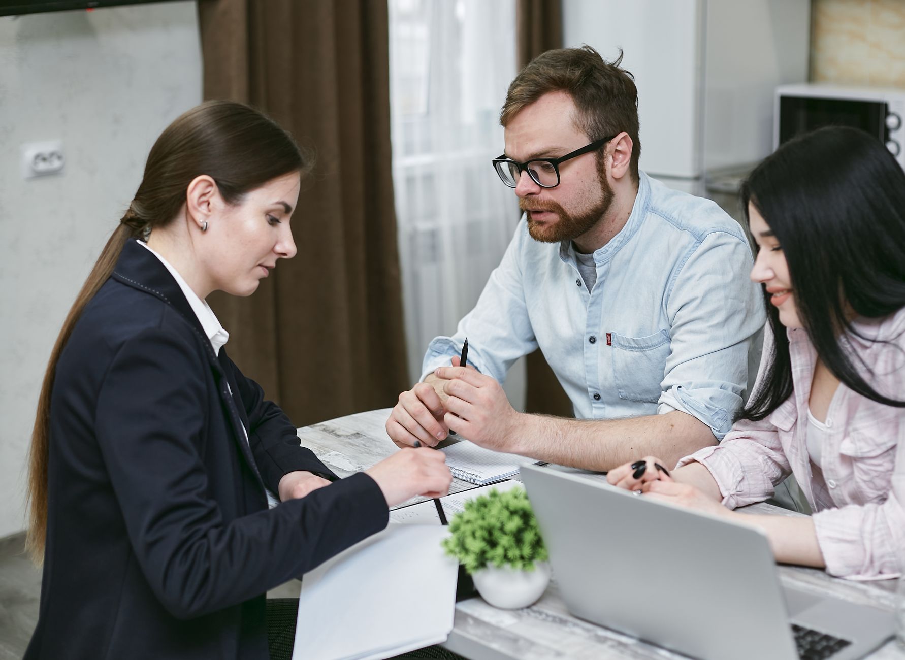 Profissional orientando clientes sobre financiamento para aquisição de imóvel residencial acessível