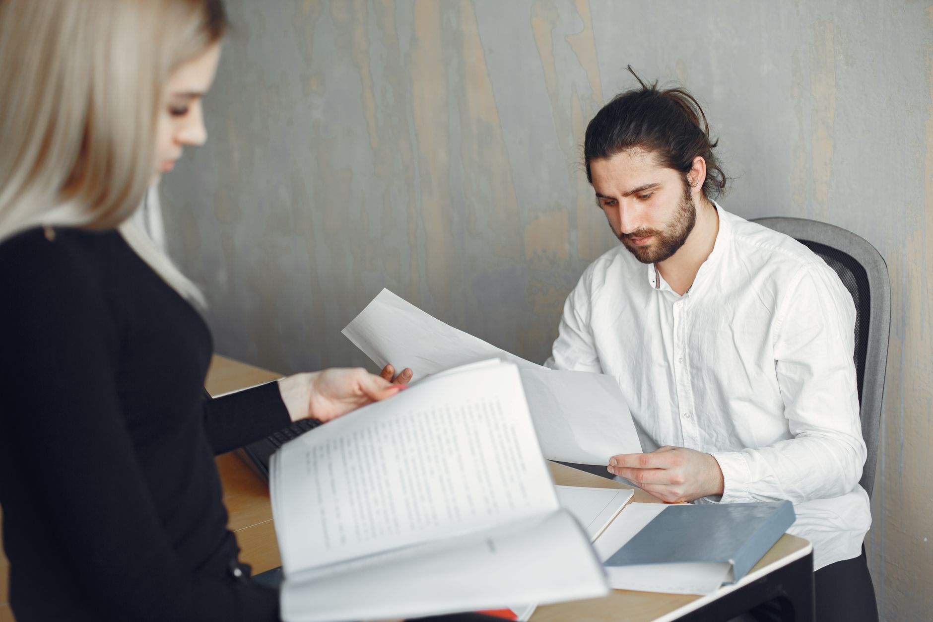 Reunião profissional entre pessoas discutindo documentos e informações técnicas em ambiente corporativo