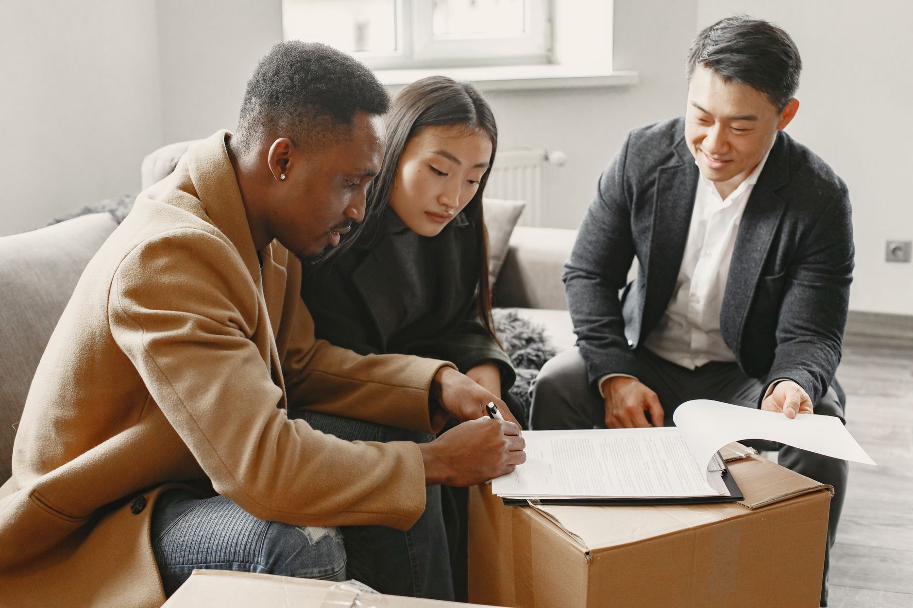 Família ou casal assinando contrato de financiamento imobiliário com consultor em ambiente residencial