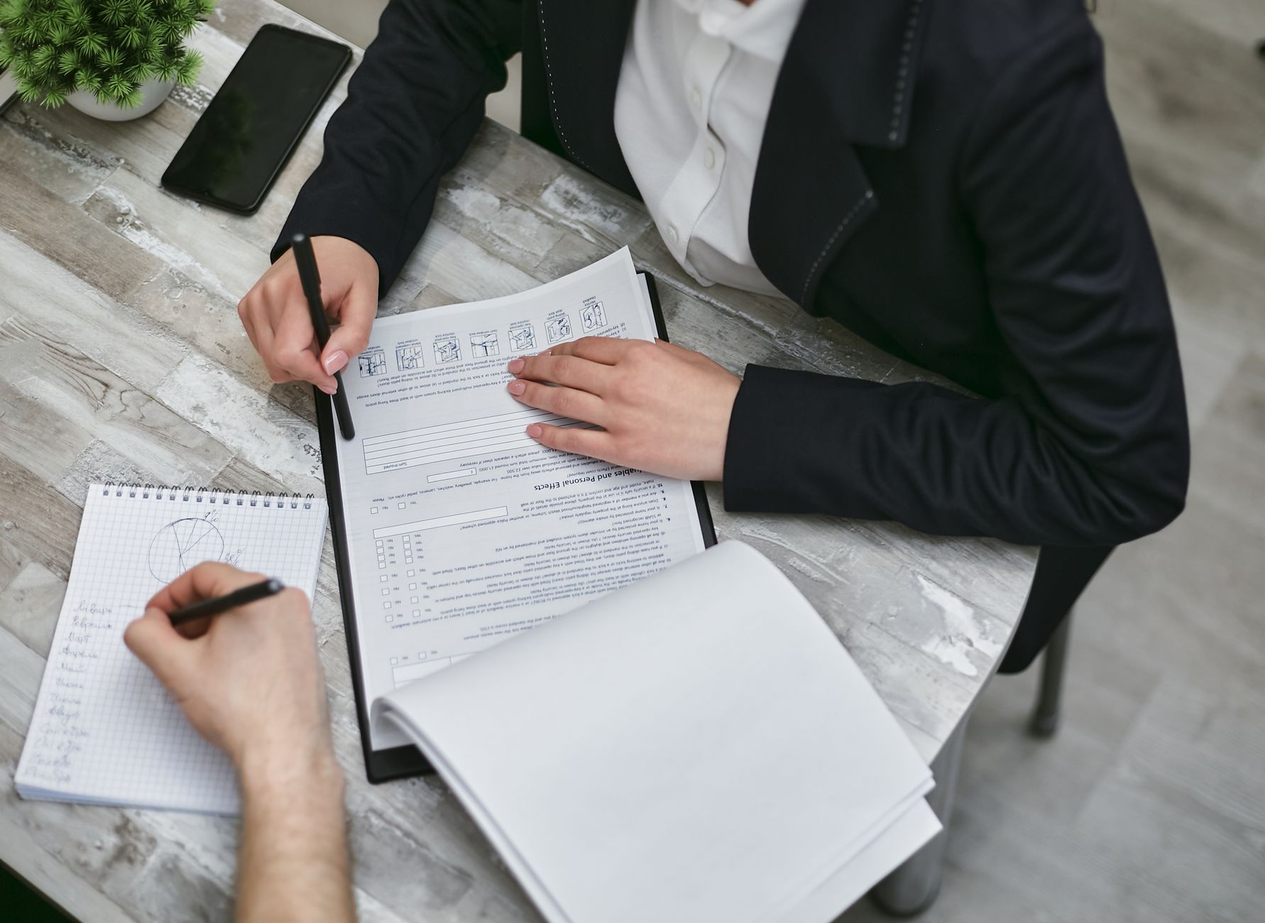 Profissional imobiliário e cliente discutem documentos de doação de imóvel em ambiente corporativo