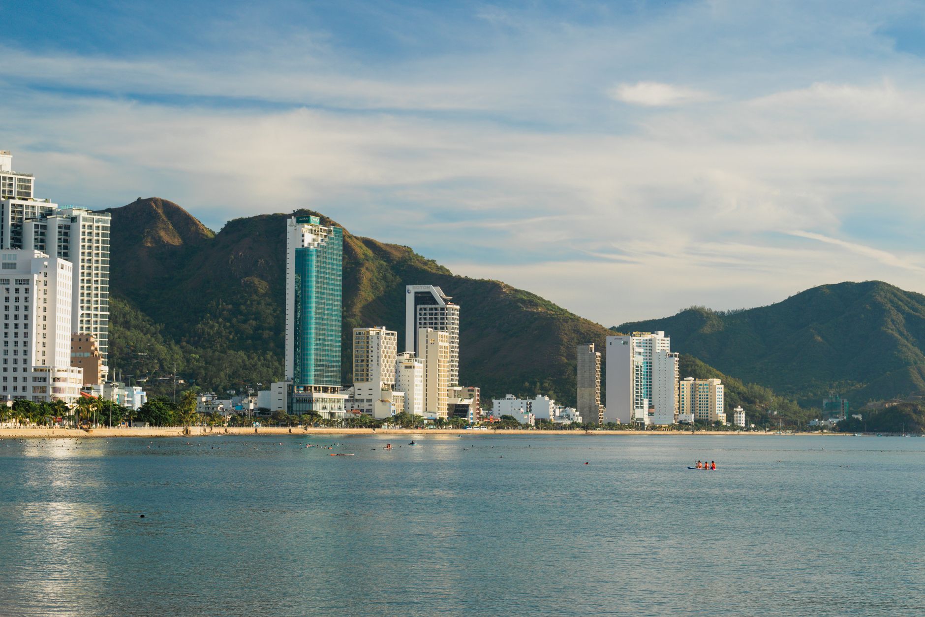 Prédio residencial alto bloqueando parcialmente a vista para o mar em uma cidade litorânea
