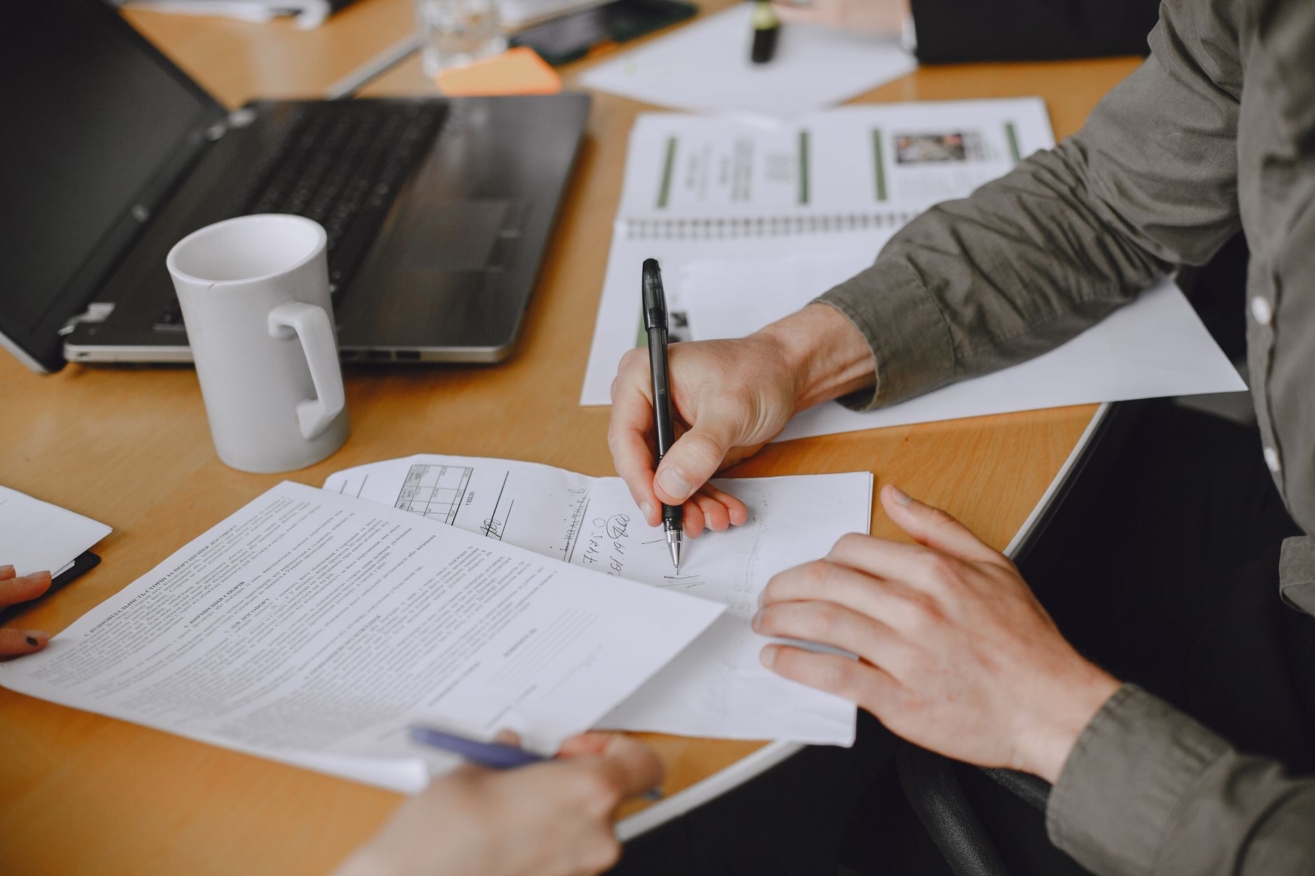 Profissional imobiliário utilizando notebook para acessar documentos digitais em ambiente de escritório moderno