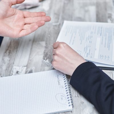 Profissionais discutindo documentos e contratos em reunião sobre gestão condominial