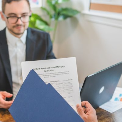 Profissionais do mercado imobiliário analisam contratos e dados financeiros em ambiente corporativo.
