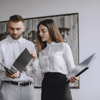Corretores e gestores imobiliários discutindo documentos para regularização de imóveis com pendências fiscais
