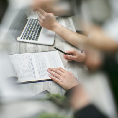 Corretor de imóveis e cliente em reunião para análise de contrato imobiliário