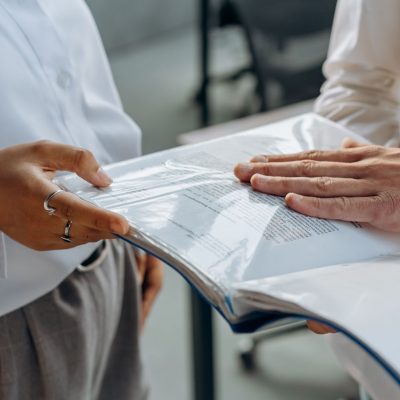 Profissional imobiliário e cliente discutindo contrato em ambiente corporativo