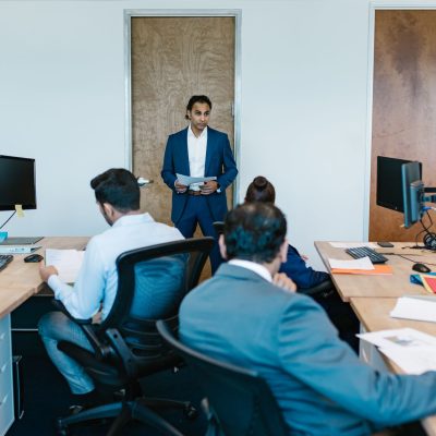 Reunião de profissionais do mercado imobiliário em ambiente corporativo moderno