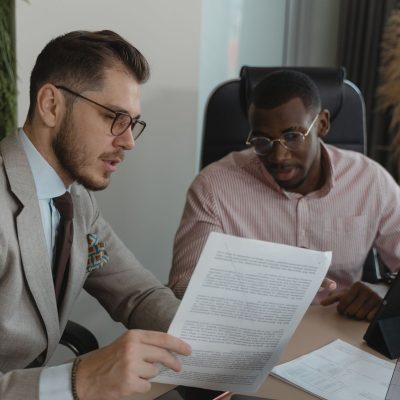 Profissional do mercado imobiliário orienta cliente durante análise de contrato e valores da negociação